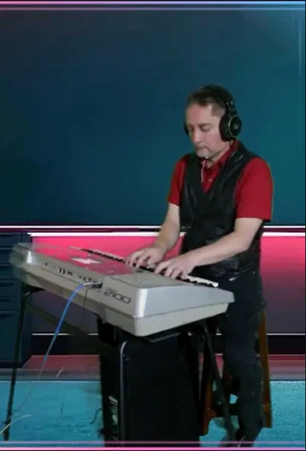 Roberth Tamayo en teclado con audífonos, ambiente de estudio