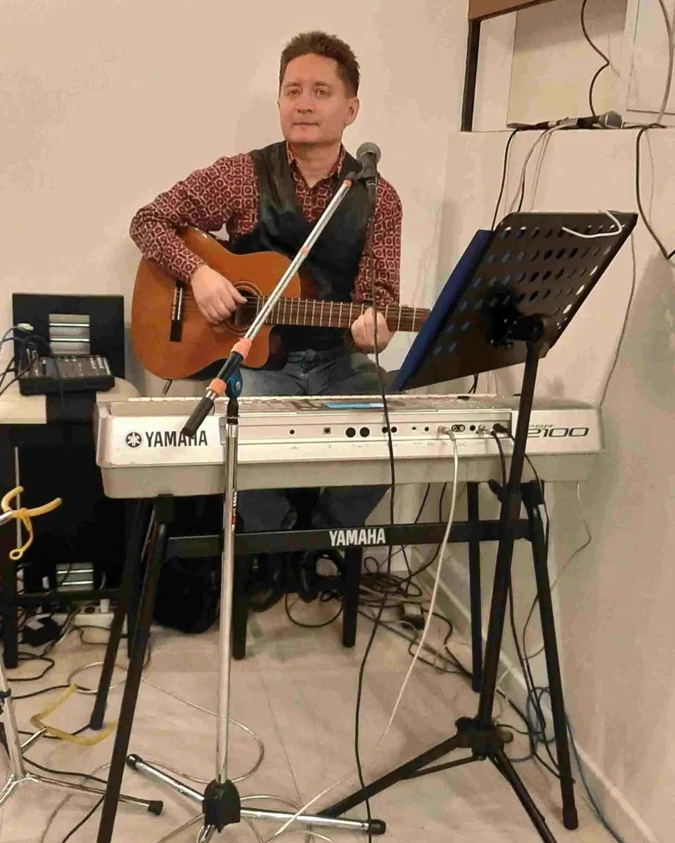 Roberth Tamayo tocando guitarra junto a teclado Yamaha